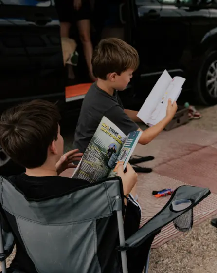 Jongens lezen en ontspannen tijdens hun kampeervakantie