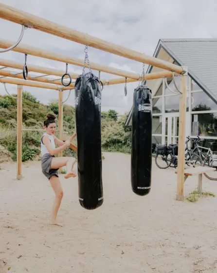 Vrouw sport buiten op het calesthenics toestel in de natuur